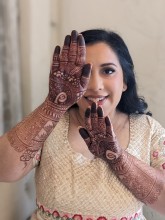 Happy bride with henna by Nisha in Austin