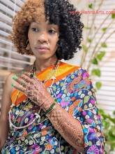 A black woman wearing saree and showing henna